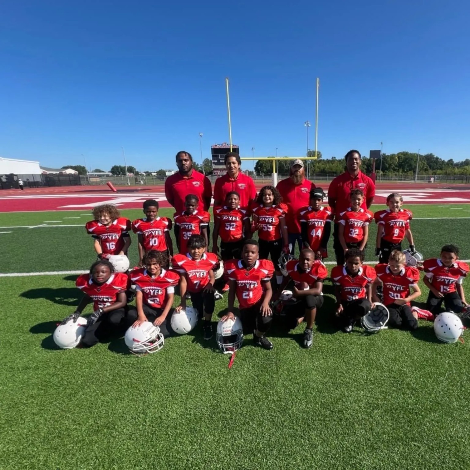 Coach Livers with a youth football team and coaching staff